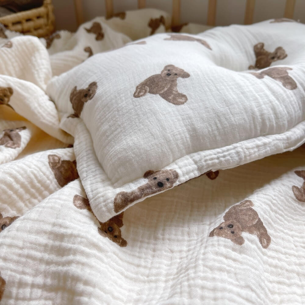 A close-up shot of the soft muslin baby blanket and pillow from the Teddy Bear set, highlighting the crinkled texture and the cute bear pattern.