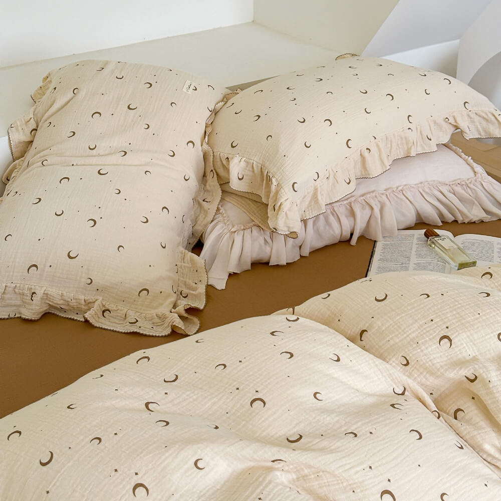 A bedroom scene featuring the moon and star print cotton muslin duvet cover set with ruffled edges