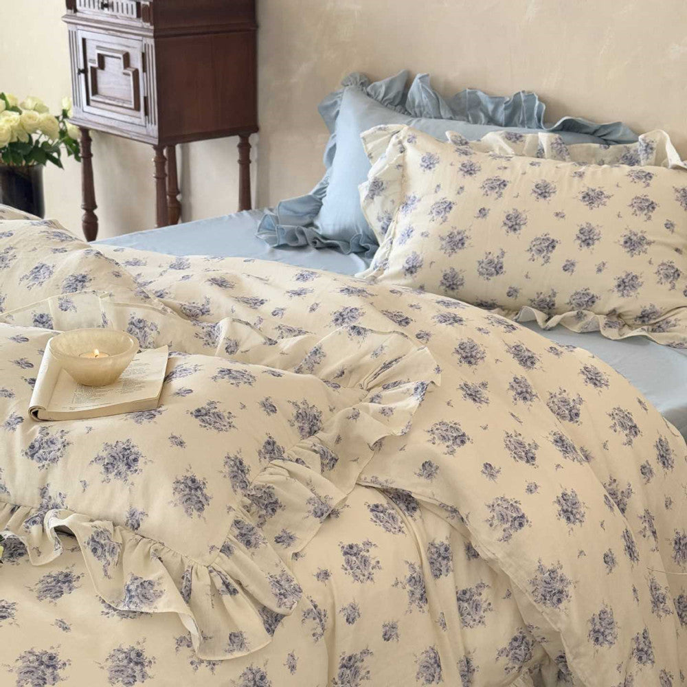 A beautifully styled bed with the Dusty Blue Floral duvet cover, featuring charming ruffle trim and a vintage-inspired floral print