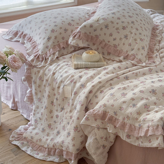 Cozy blush floral cottom comforter near window with soft light
