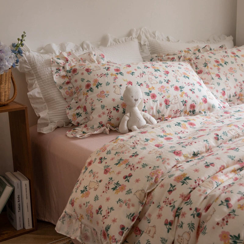 A cozy bed styled with a pink floral bunny bedding set, featuring a cotton gauze duvet cover and pillows with ruffle trim.