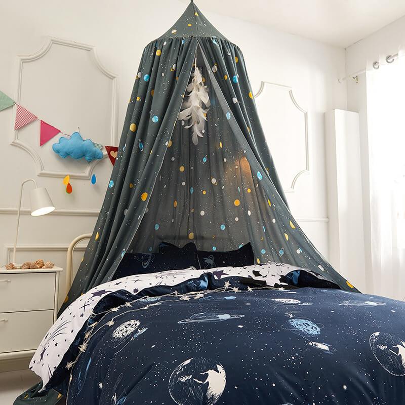 Gray space adventure bed canopy with planets and stars, styled over a crib with coordinating bedding.