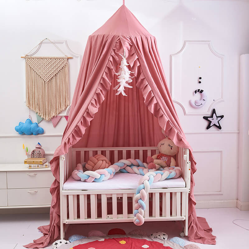 Pink ruffled nursery canopy made of soft polyester, shown over a crib.