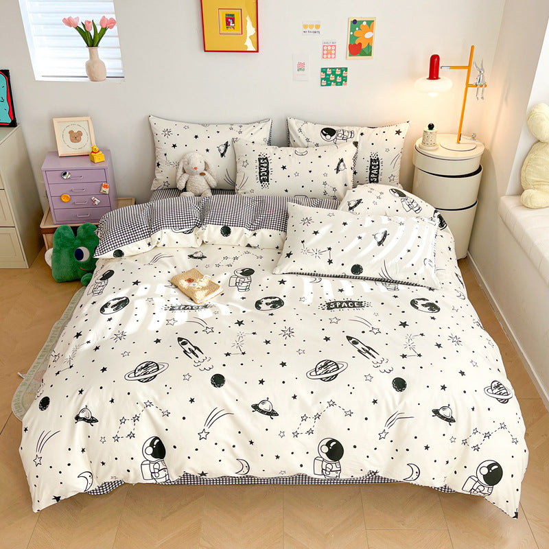 A child's bedroom with a twin-size bed featuring a white outer space cotton bedding set. The duvet cover has black and white illustrations of rockets, astronauts, and planets.
