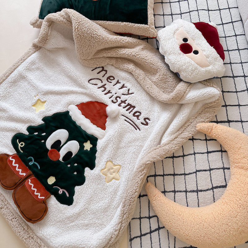 A reversible plush sherpa throw blanket with a Christmas tree design, featuring "Merry Christmas" embroidery and a Santa pillow.