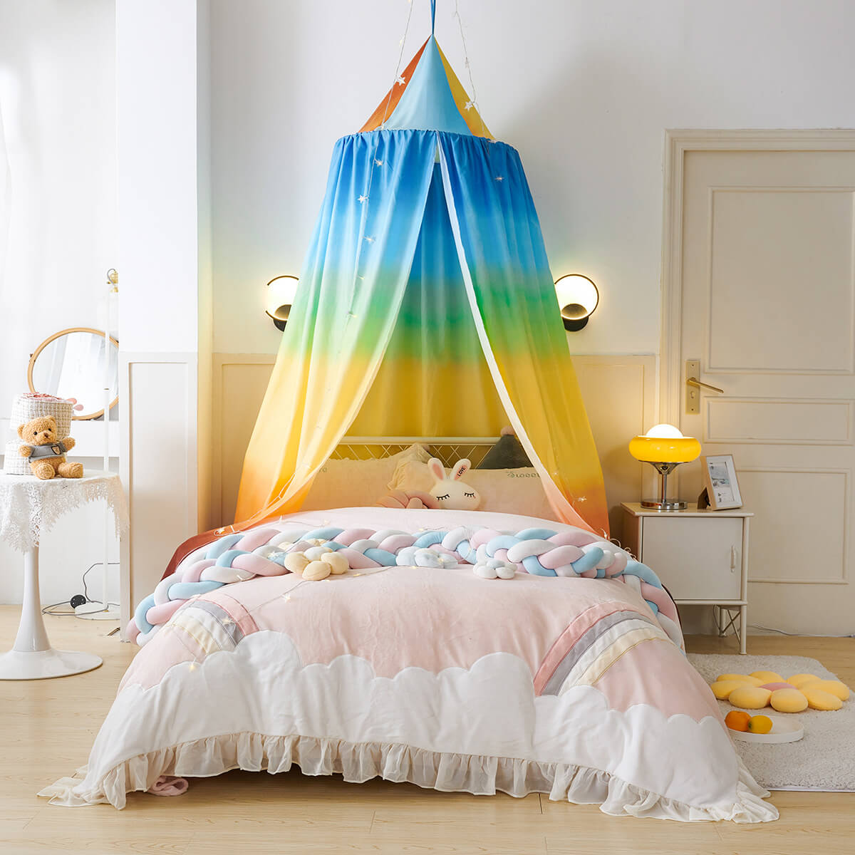 Rainbow kids bed canopy with a colorful gradient, styled over a bed with cloud bedding.
