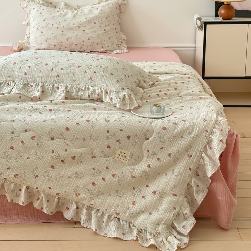 Bunny floral muslin quilt with ruffle edge on bed