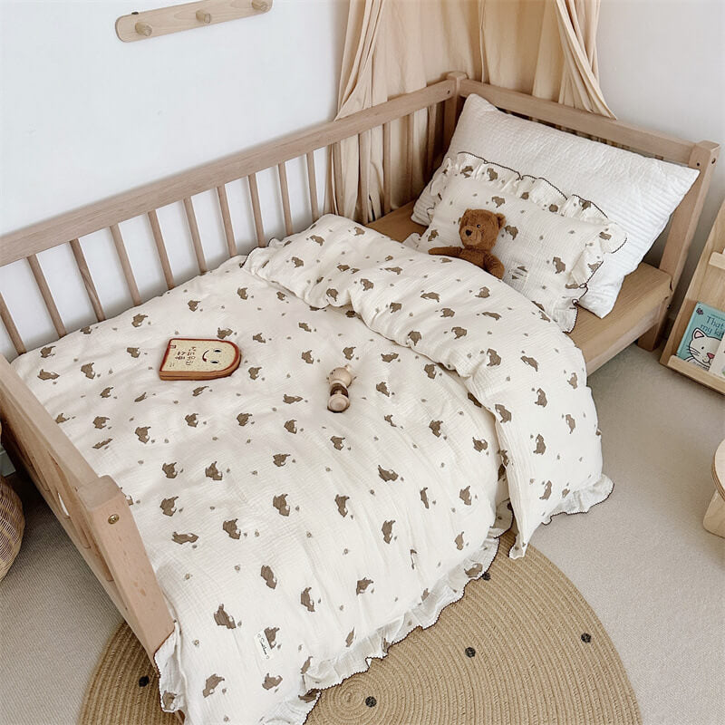 Bear print muslin pillow with ruffle and plush teddy bear on brown flat sheet