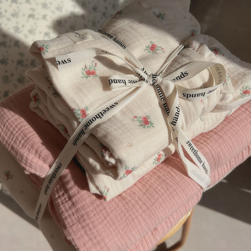 Folded floral cotton bedding set in vintage rose print, tied with ribbon