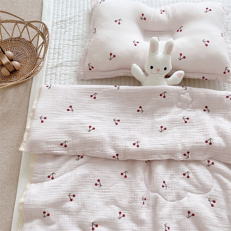 Close-up of cherry print baby quilt fabric and lace edge