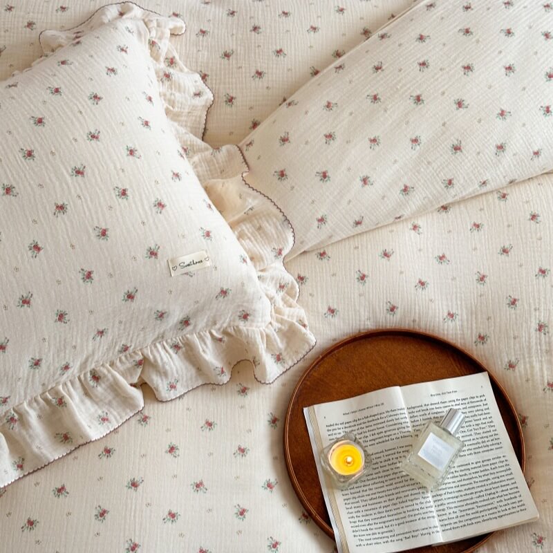 Close-up of petite rosebud print and ruffled edge on muslin bedding set