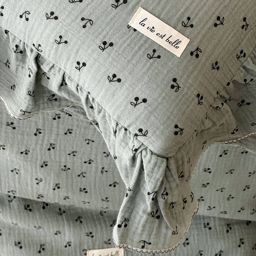 Detail shot of the cute toddler bedding set, showing the ruffled pillow sham with a delicate floral print