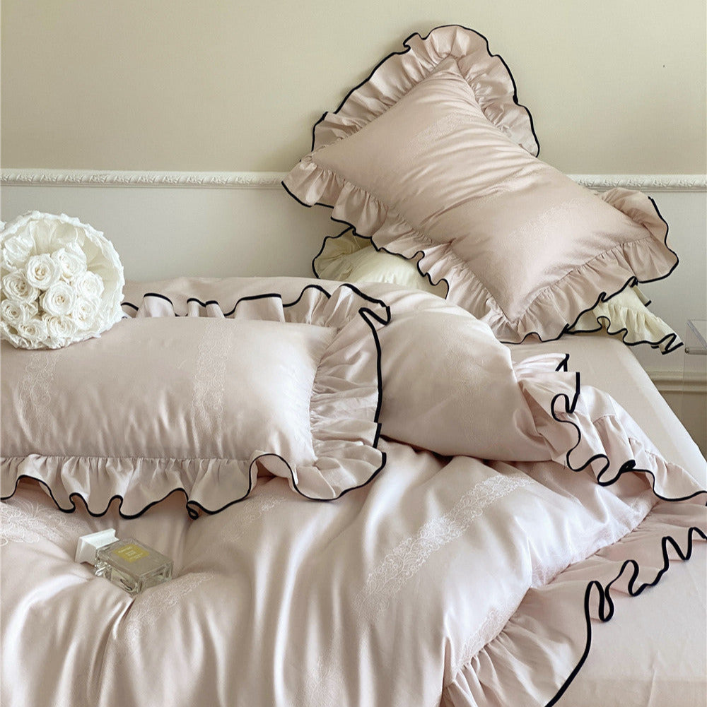 Silky pink duvet cover with elegant black piping and ruffled trim