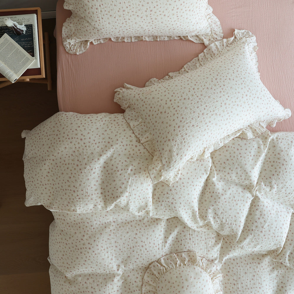 Top view of ditsy floral duvet cover and ruffled pillowcases on pink sheet
