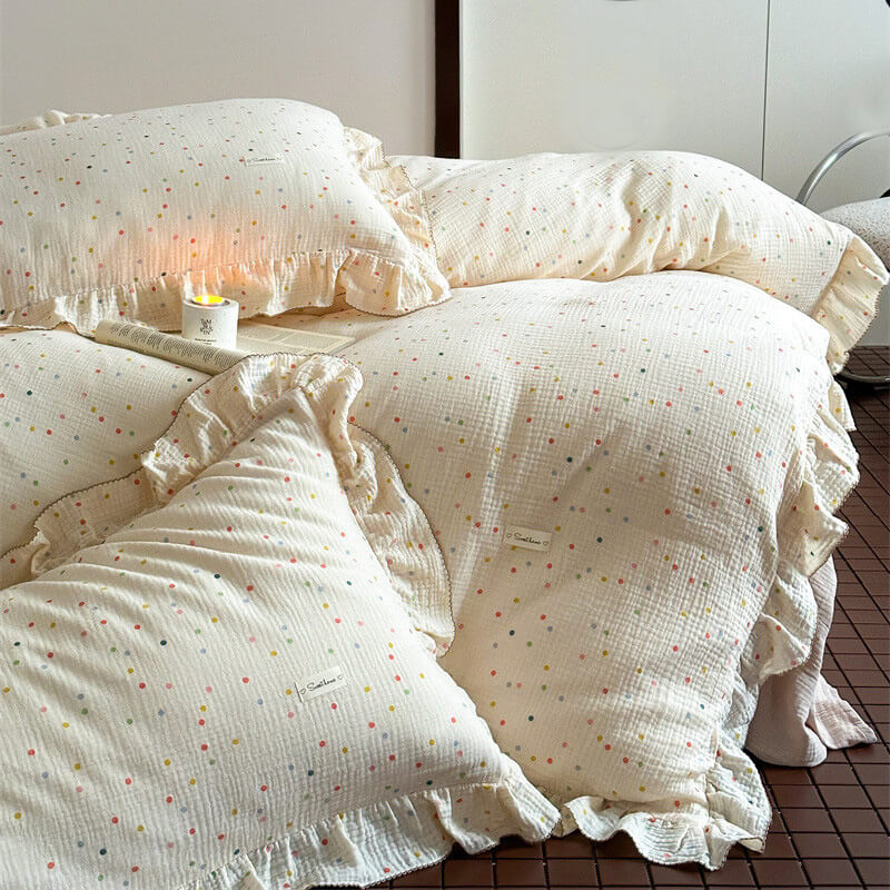 Cotton muslin bedding set with colorful polka dot print and ruffle trim on bed