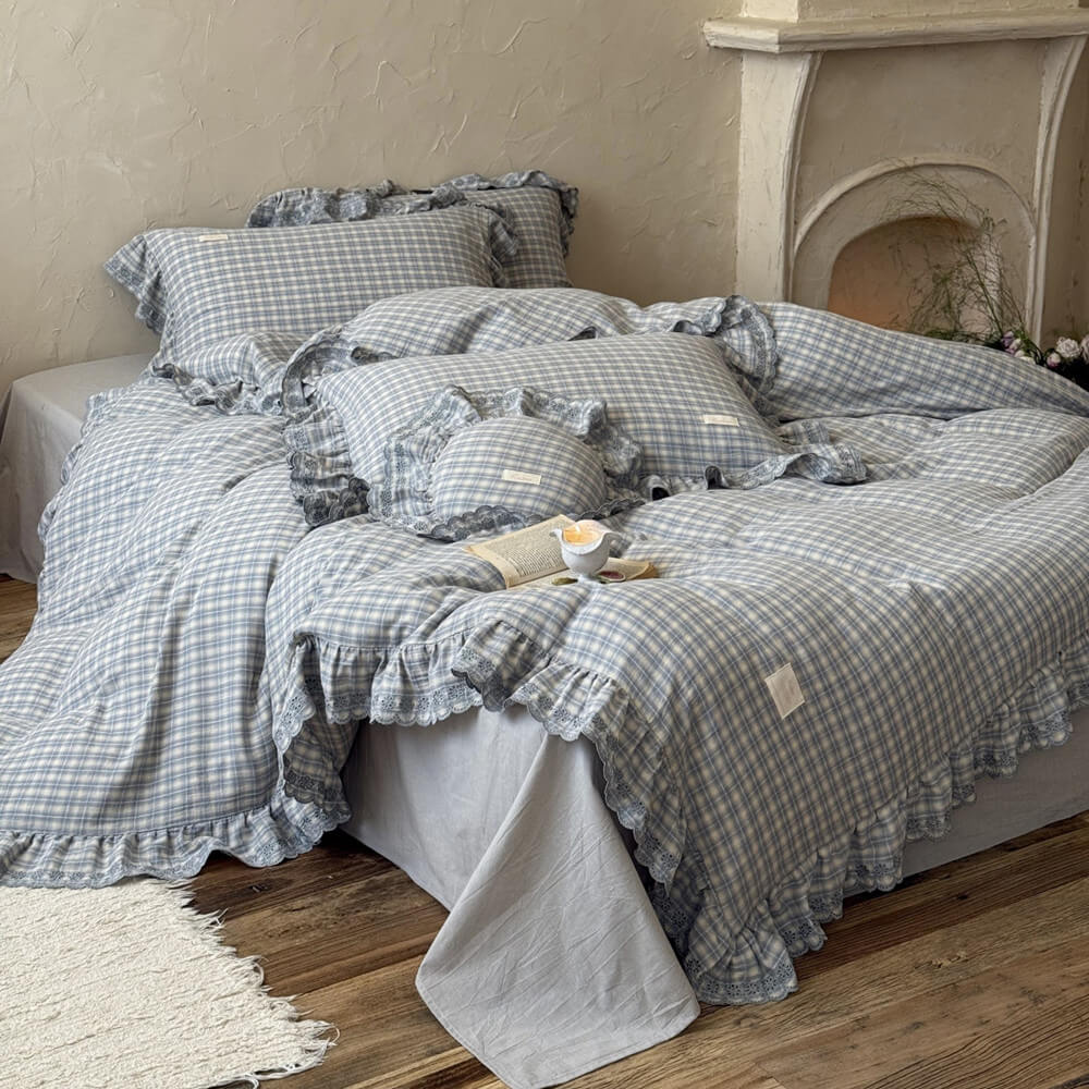 Gray checkered bedding set on a bed with a fireplace in the background