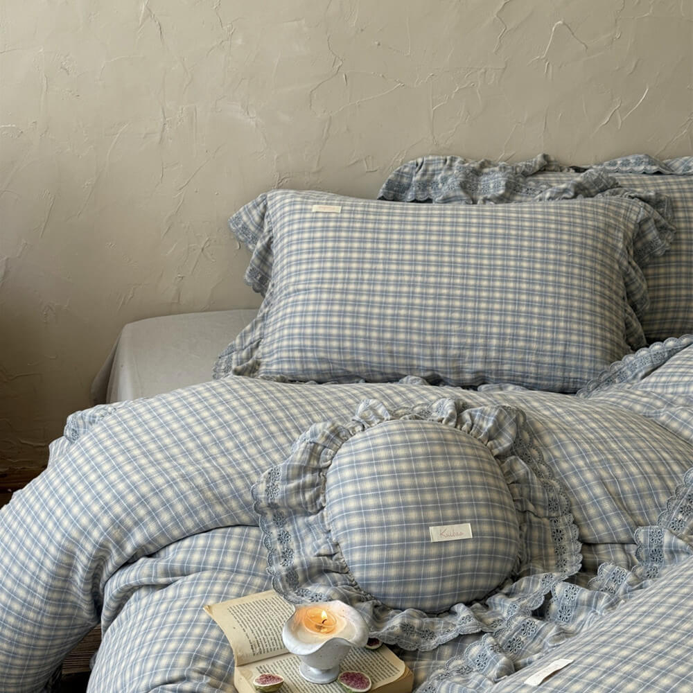 Blue plaid bedding with ruffled round decorative pillow and soft lace trim