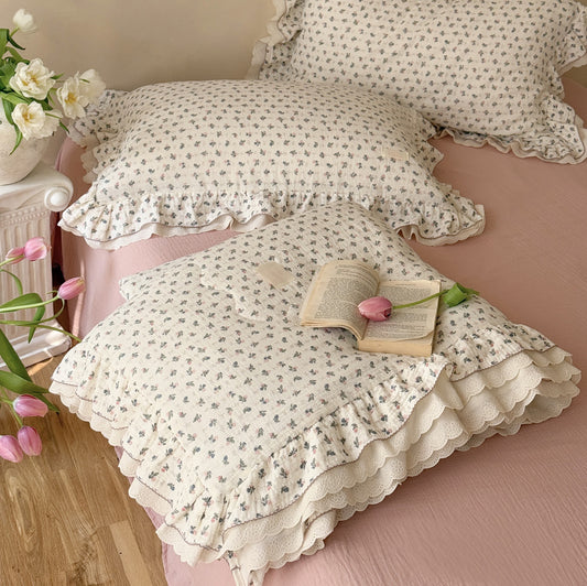 Dusty rose floral cotton comforter styled in bright bedroom with natural light and flowers