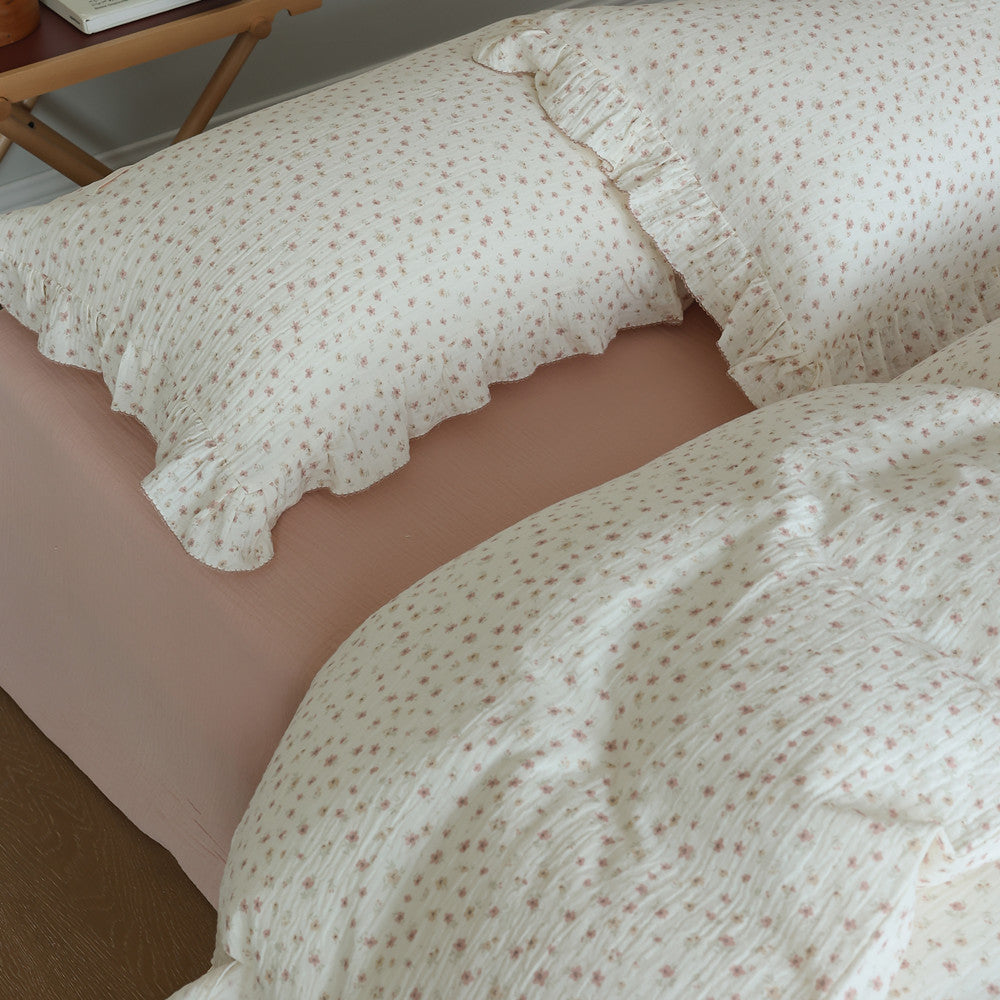 Small floral ruffle pillow and duvet on bed with matching pattern