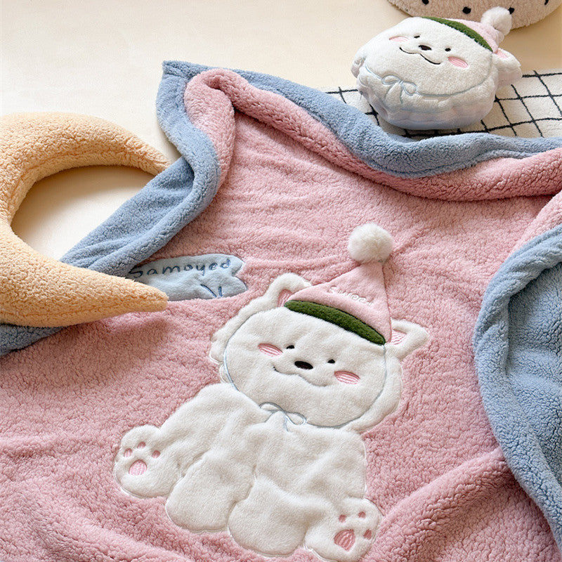 Close-up of the embroidered Samoyed dog on a soft sherpa blanket.