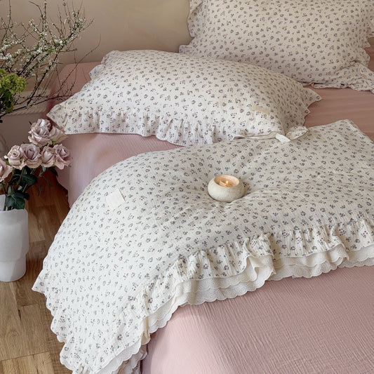 Candlelit detail shot of Ditsy Floral Kids Comforter folded over the pink bedspread.