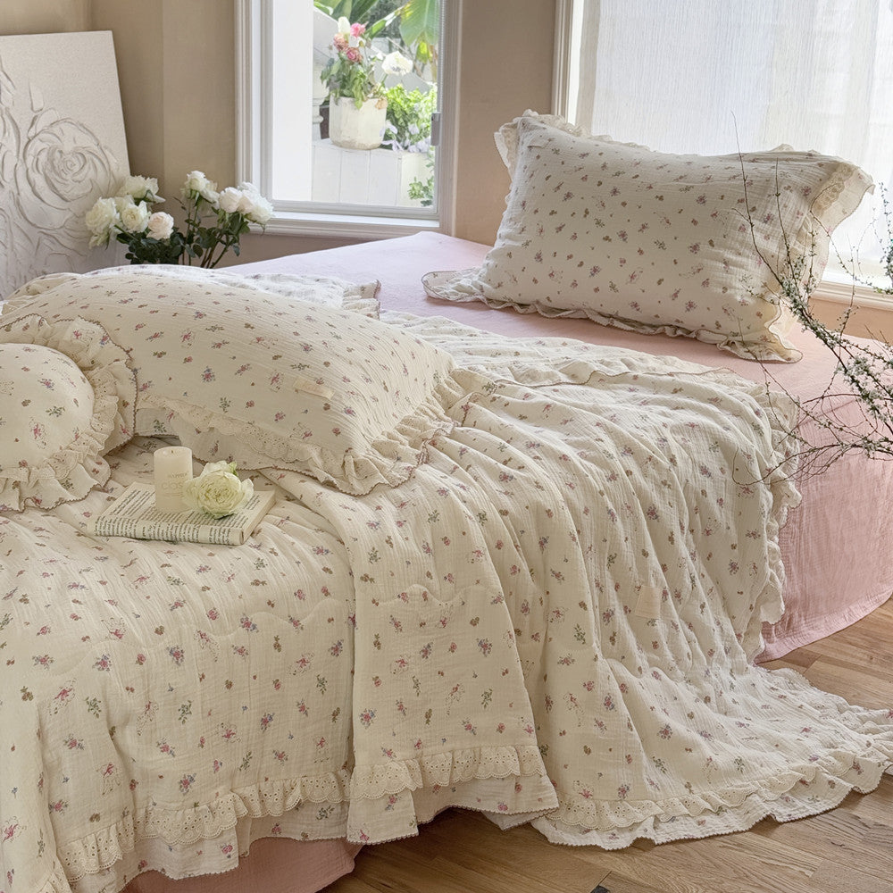 Soft floral comforter with lace ruffle edge on pink gauze bed