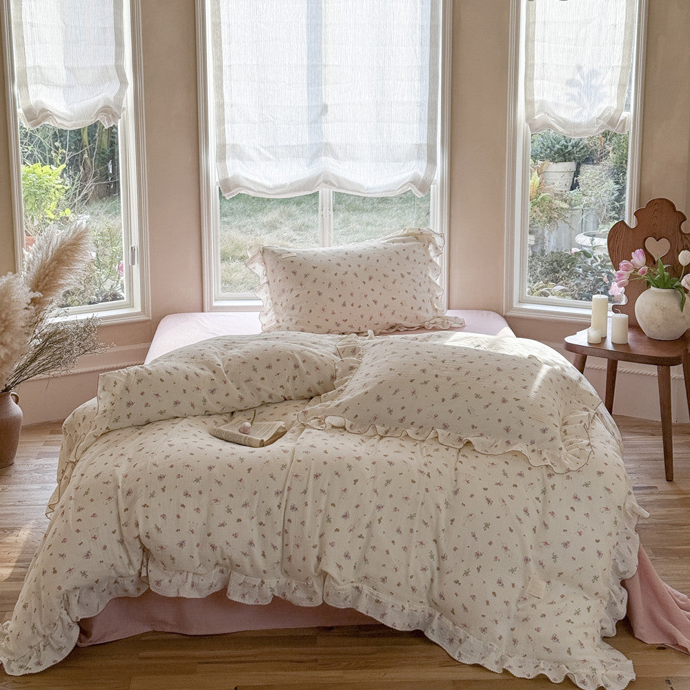 Full view of pink rose floral bedding set with ruffles in bright window room