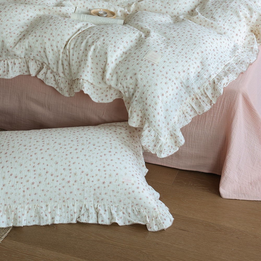 Ruffled cotton duvet cover set with pink ditsy floral print on a bed