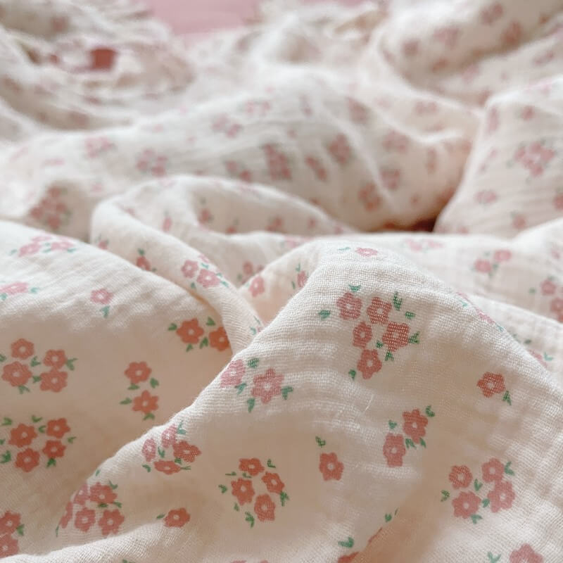 Close-up of ditsy pink flower print on cotton gauze fabric