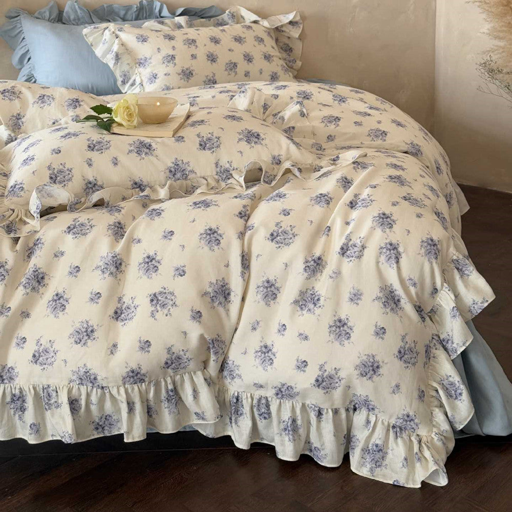 French country ruffled bedding set styled on a bed, with a close focus on the soft, flowing ruffle details of the duvet cover and pillow shams.