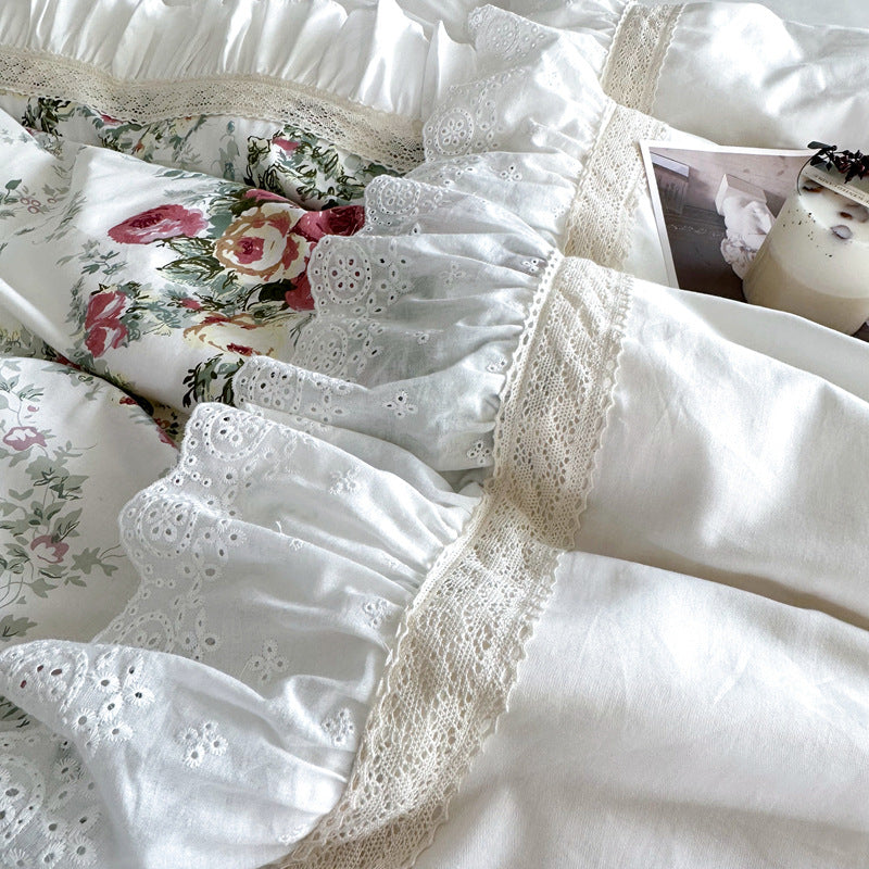 Close-up of lace and ruffles on white floral cotton bedding