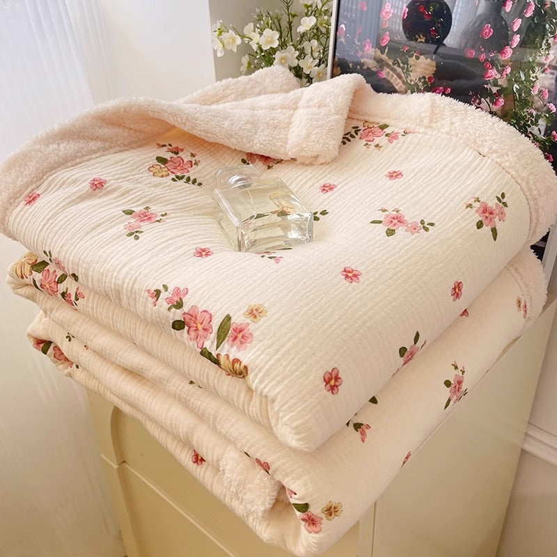 A hommey reversible throw blanket featuring a charming pink floral pattern on one side and cozy fleece on the other.
