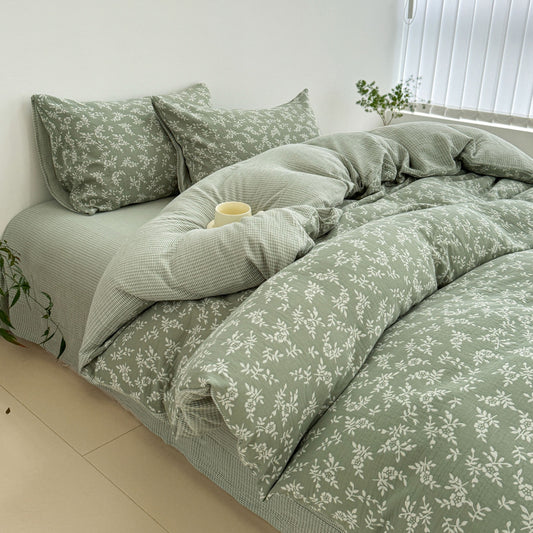 A side view of the green jacquard cotton duvet cover set, highlighting the texture and drape of the fabric on the bed.