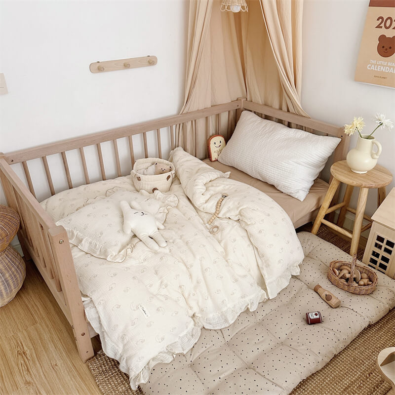 Minimalist kids’ room with lamb print ruffle duvet cover set in soft cotton muslin and natural wood furniture