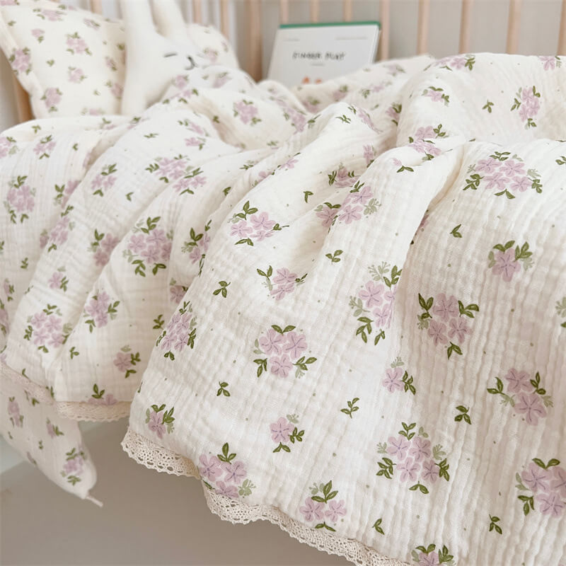 Lavender floral baby quilt with lace trim on white muslin fabric