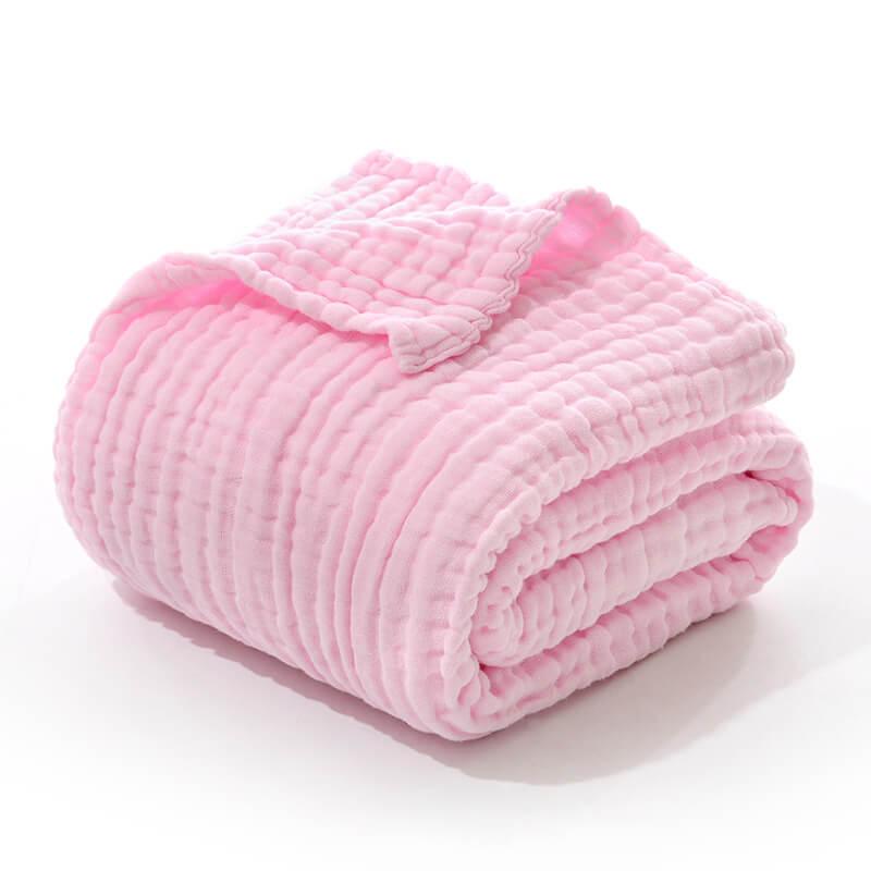 Folded 6-layer cotton muslin swaddle blanket in a solid light pink color.