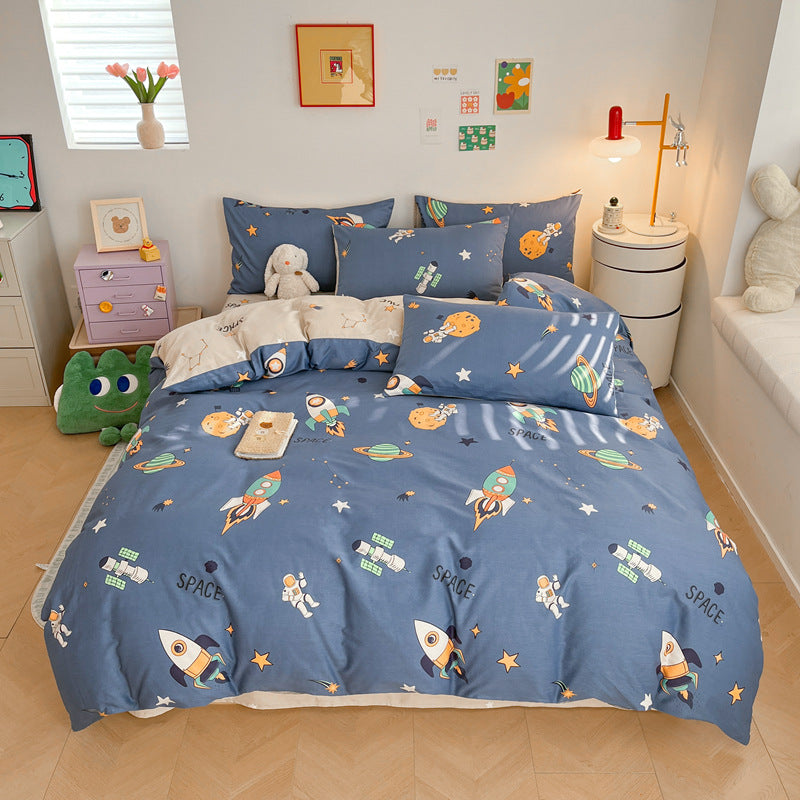 A bed styled with an outer space cotton bedding set. The duvet cover is solid navy blue with a pattern of colorful rockets, stars, and planets.
