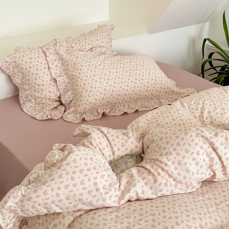 Pink floral ruffle duvet and pillows on mauve bed sheet