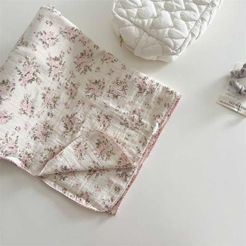 Folded rosebud pink floral muslin baby blanket with delicate edge trim