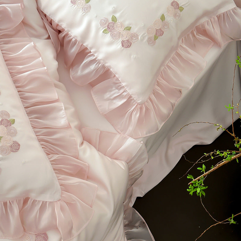 Cluster of pink ruffled pillows with embroidery