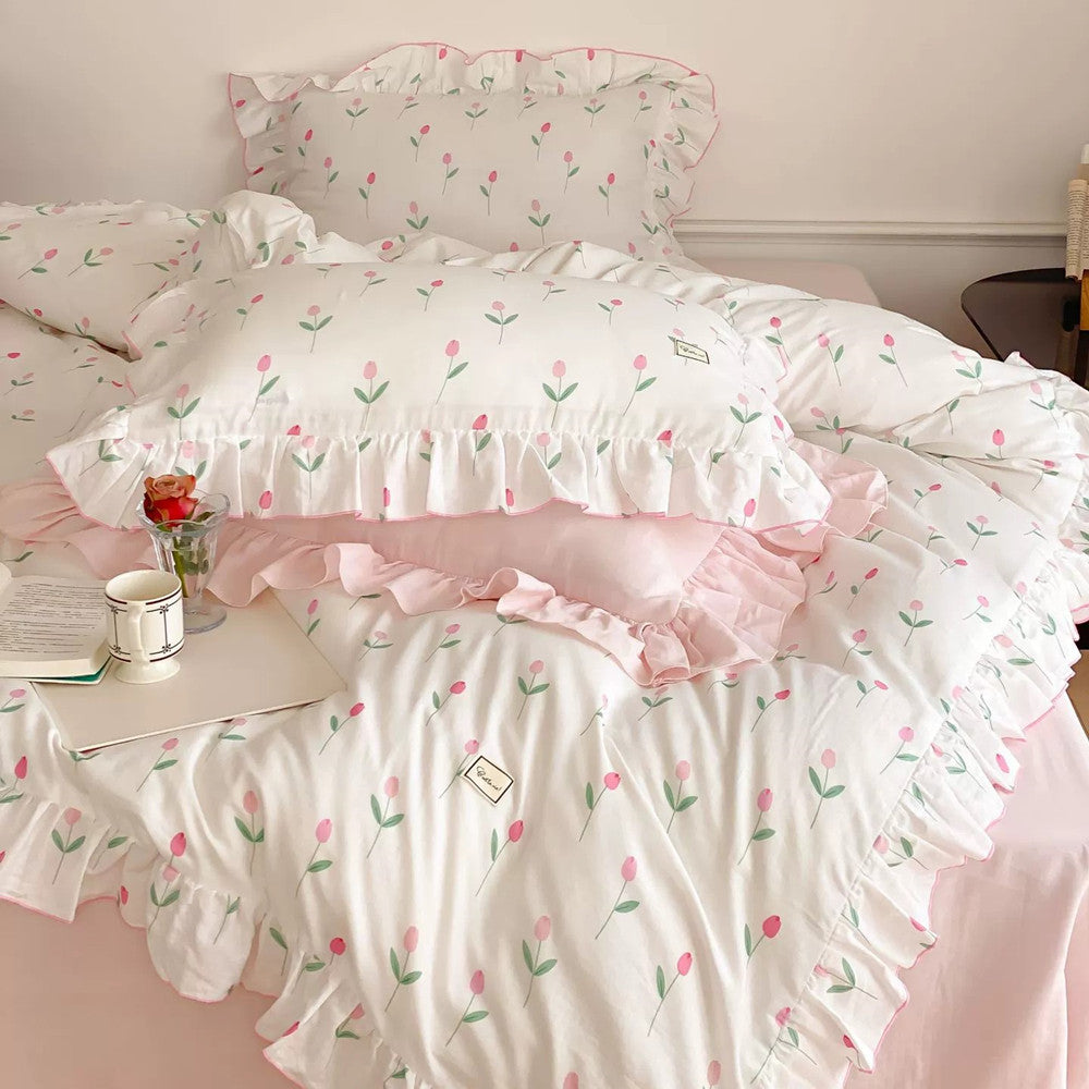 A bed with a pink tulip print cotton bedding set, featuring ruffle trim