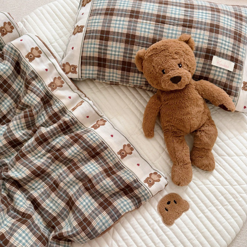 Detailed stitching and fabric weave of toddler comforter in plaid style
