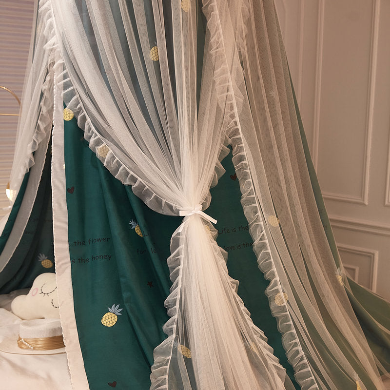 Close-up of green fabric bed canopy with pineapple print and mesh layer