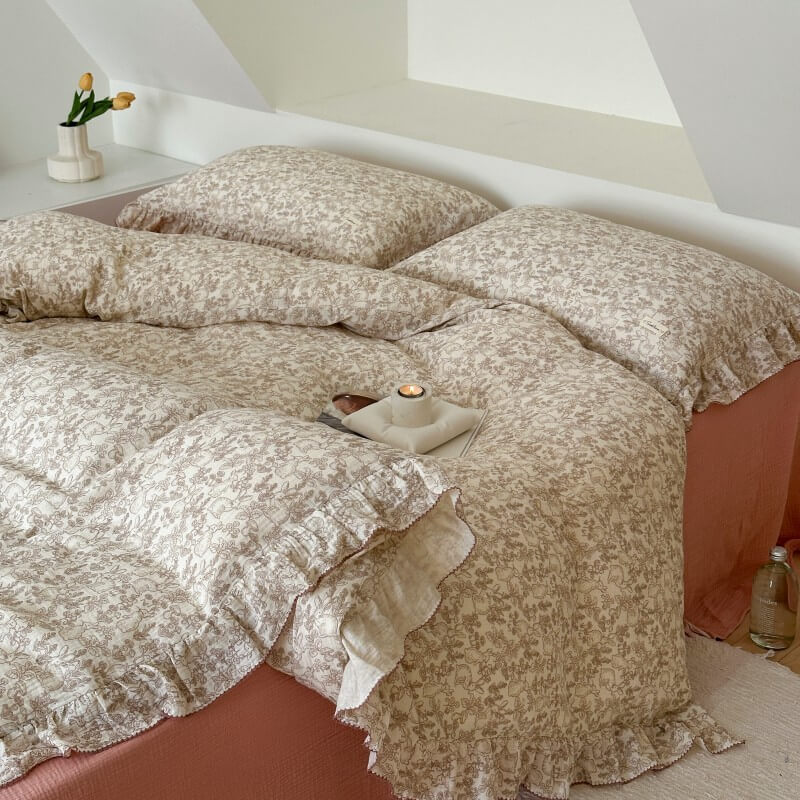 Close-up of woodland bedding and ruffled pillow on dusty rose sheet