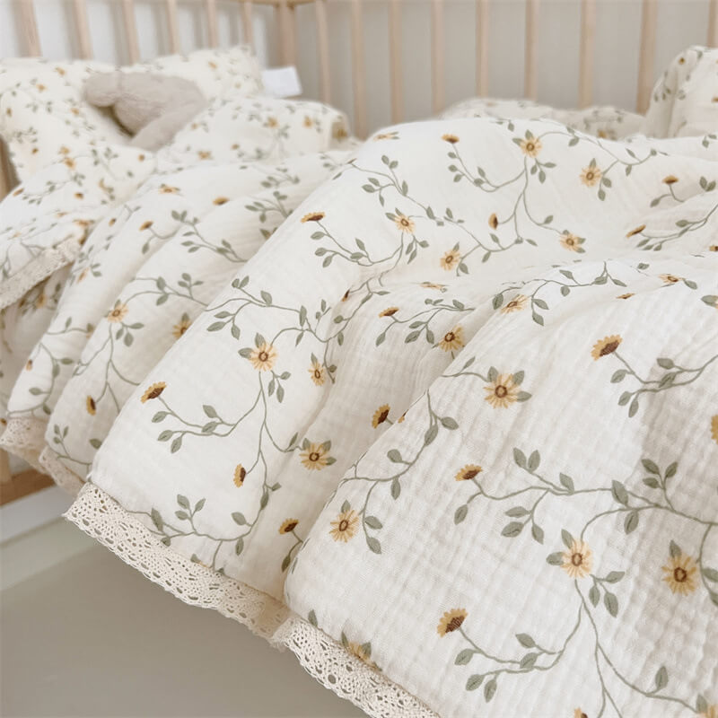 Close-up of daisy vine floral print and quilt stitching on baby quilt
