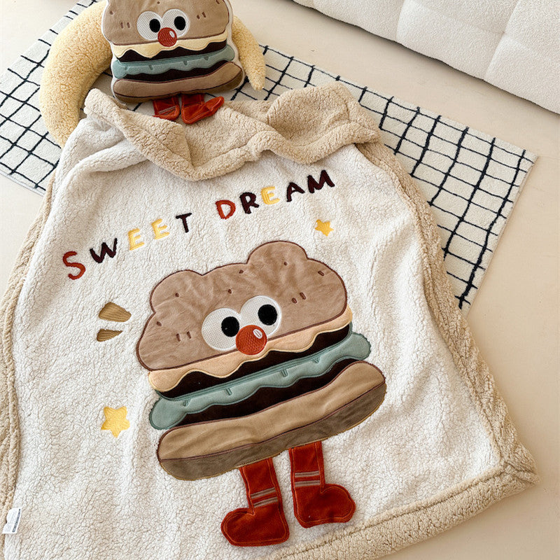 A close-up, flat-lay view of a warm sherpa baby blanket with a cute hamburger design.