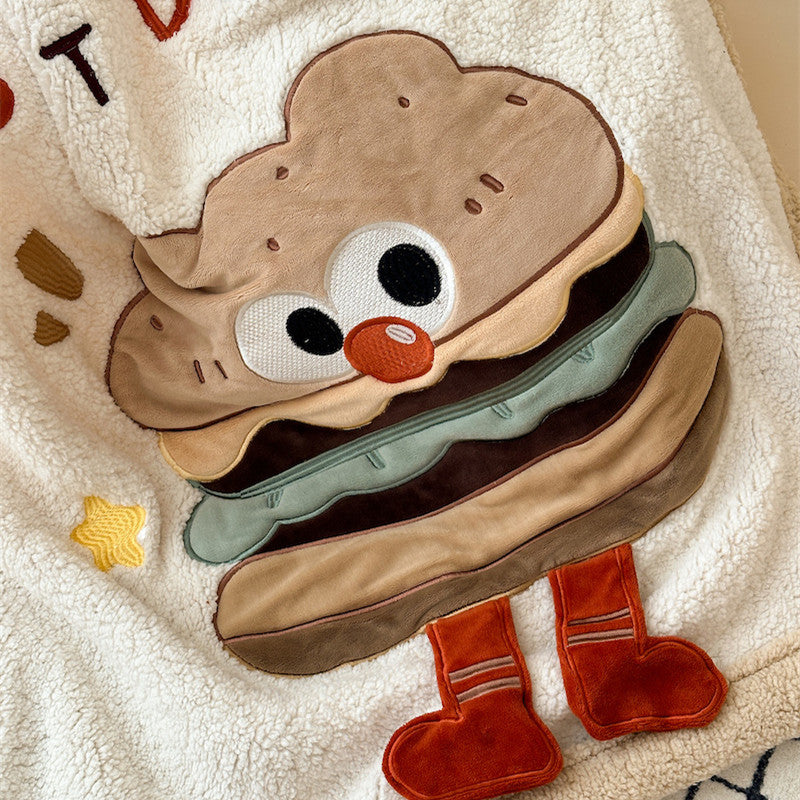 A detailed shot of the embroidered hamburger character on a soft sherpa fleece baby blanket.