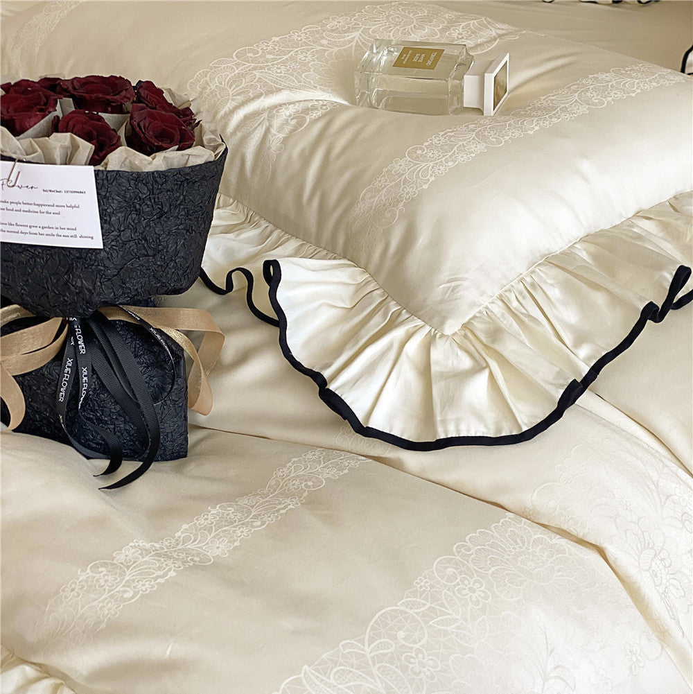 Close-up of ivory cotton sateen bedding with jacquard pattern and black ruffled edges