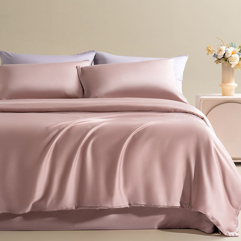 Silky Lyocell bedding set in a luxurious rose pink, layered with accent pillows to create a sophisticated and cozy bed.