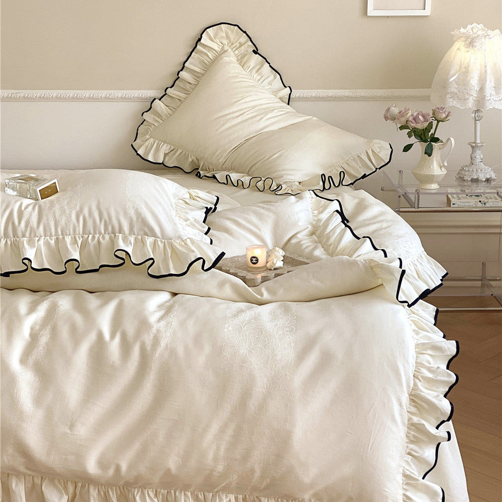 French-style ruffle bedding in ivory with bold black piping on duvet and pillows
